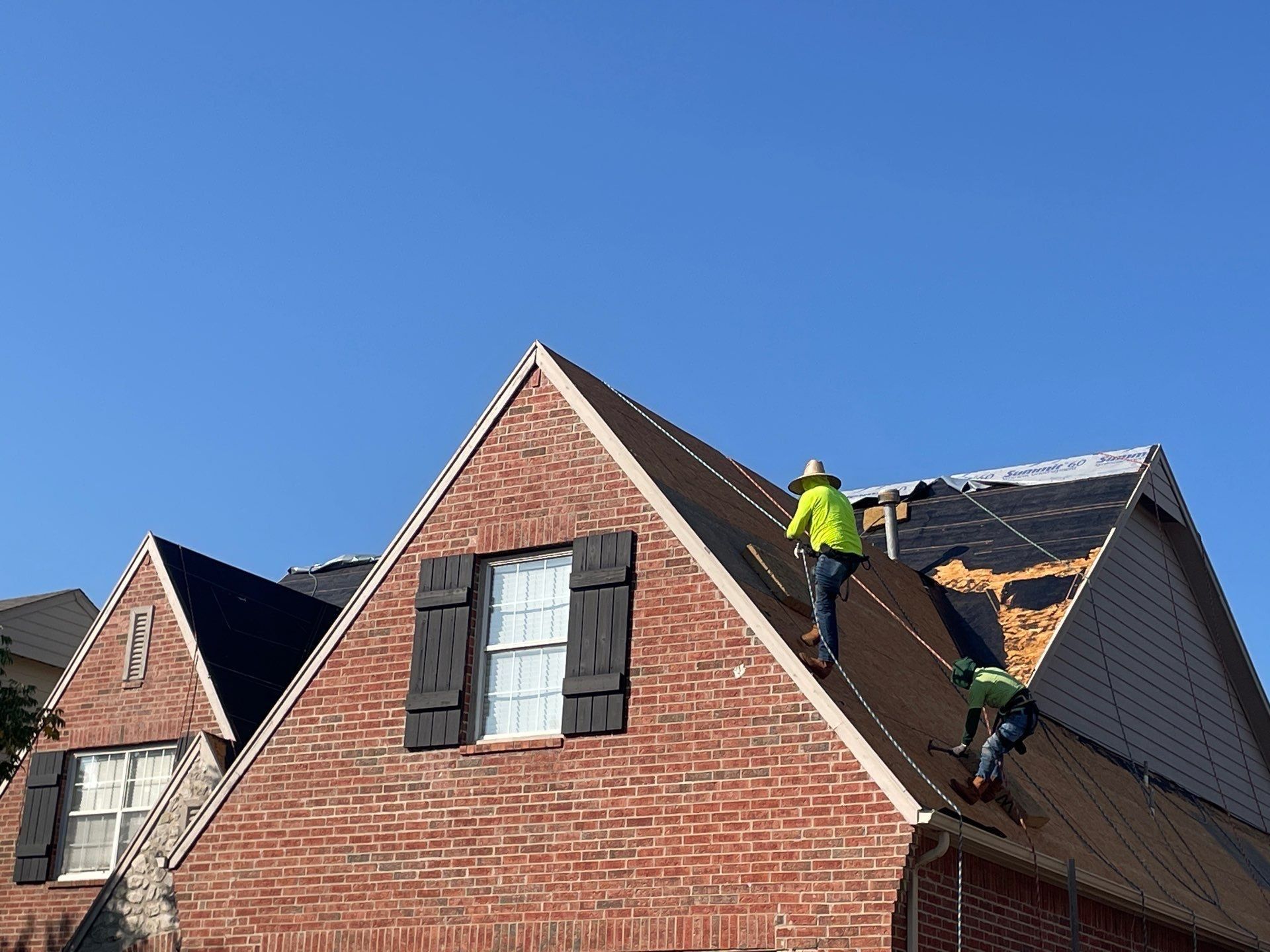 Roofing contractor installing a new shingle roof